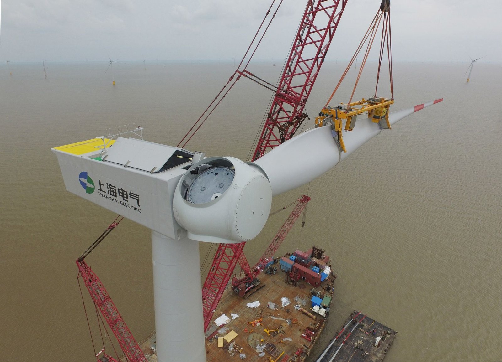 An offshore wind turbine installation vessel working at sea beside a partly built turbine
