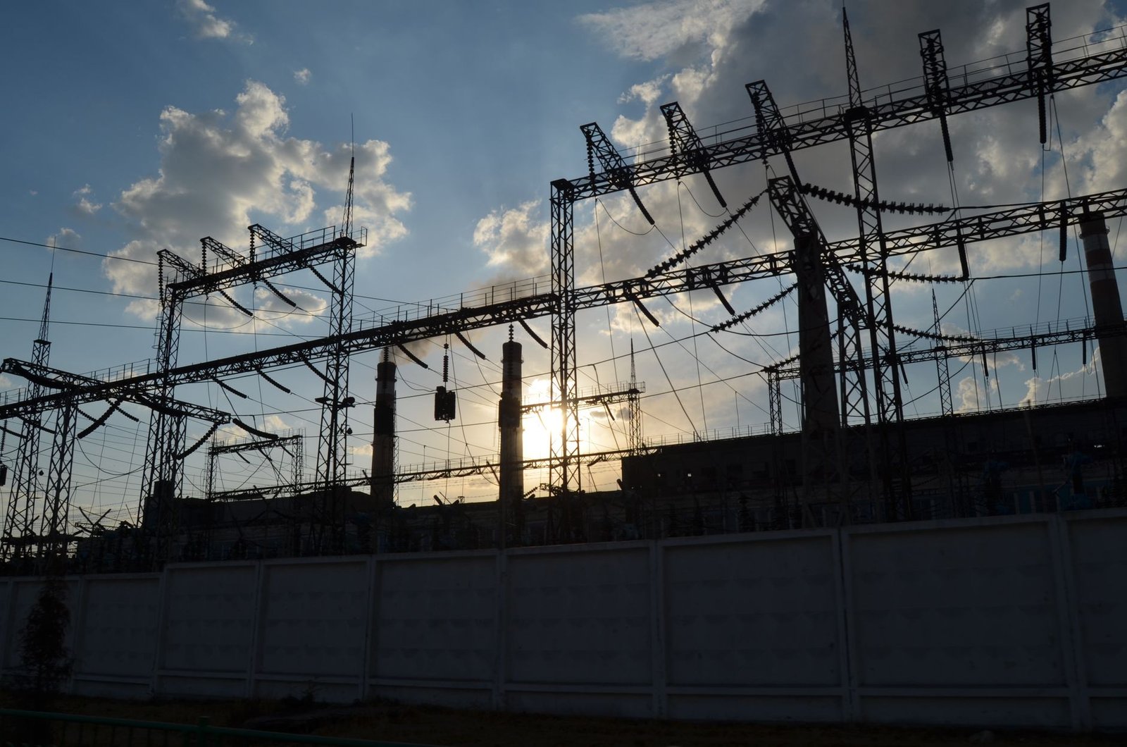 Grid-scale battery storage containers at a utility substation, on the grid's side of the meter
