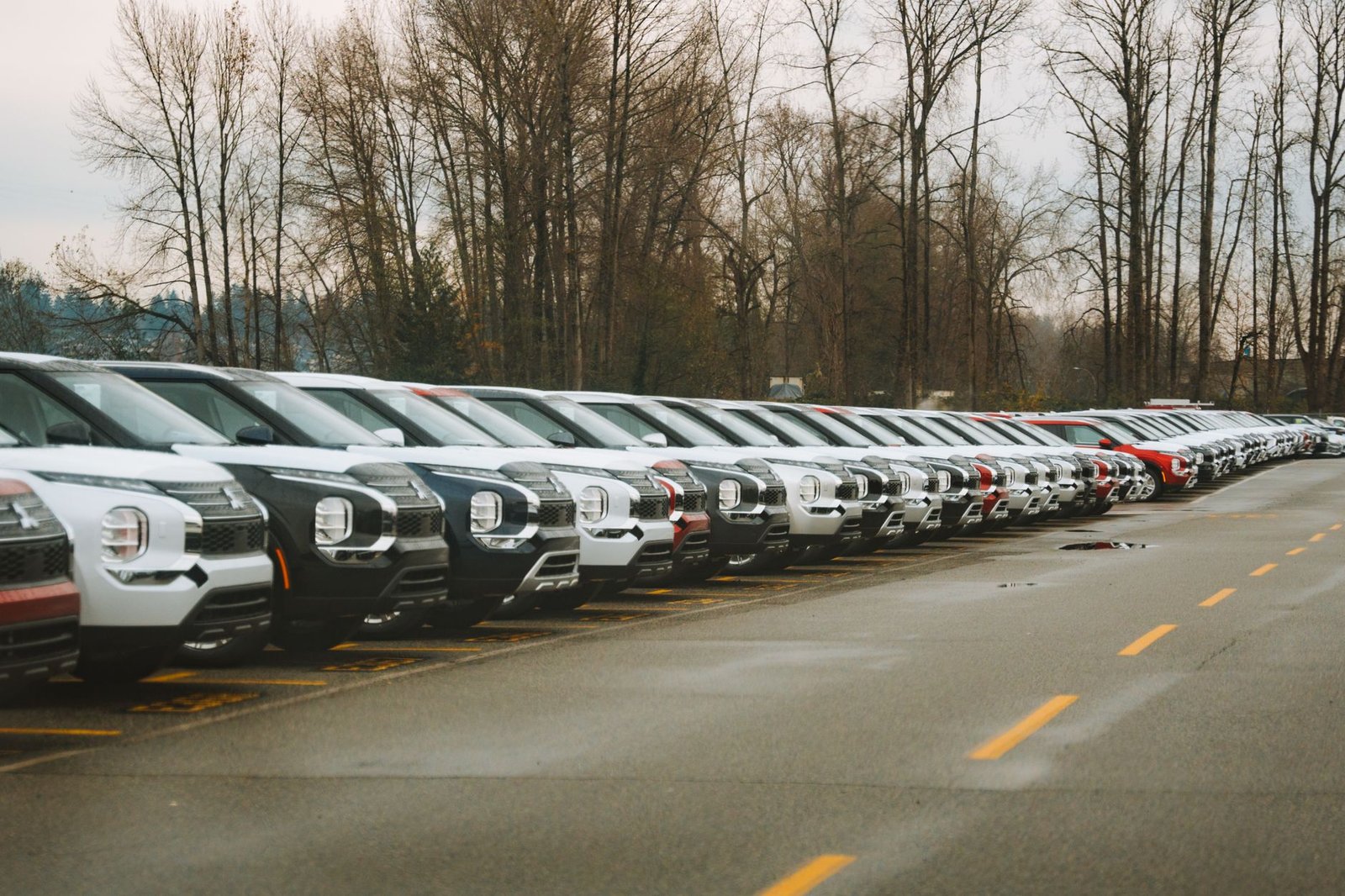 Rows of new cars parked at a dealership lot