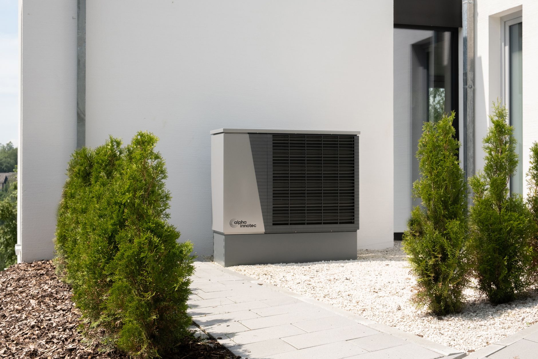 An air-source heat pump unit installed outside a house