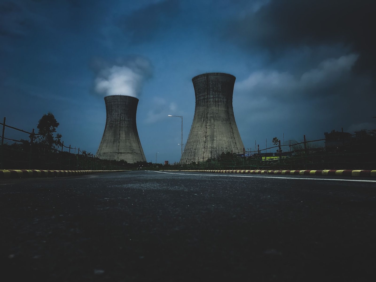 A natural gas power plant with turbine halls and stacks against a dusk sky