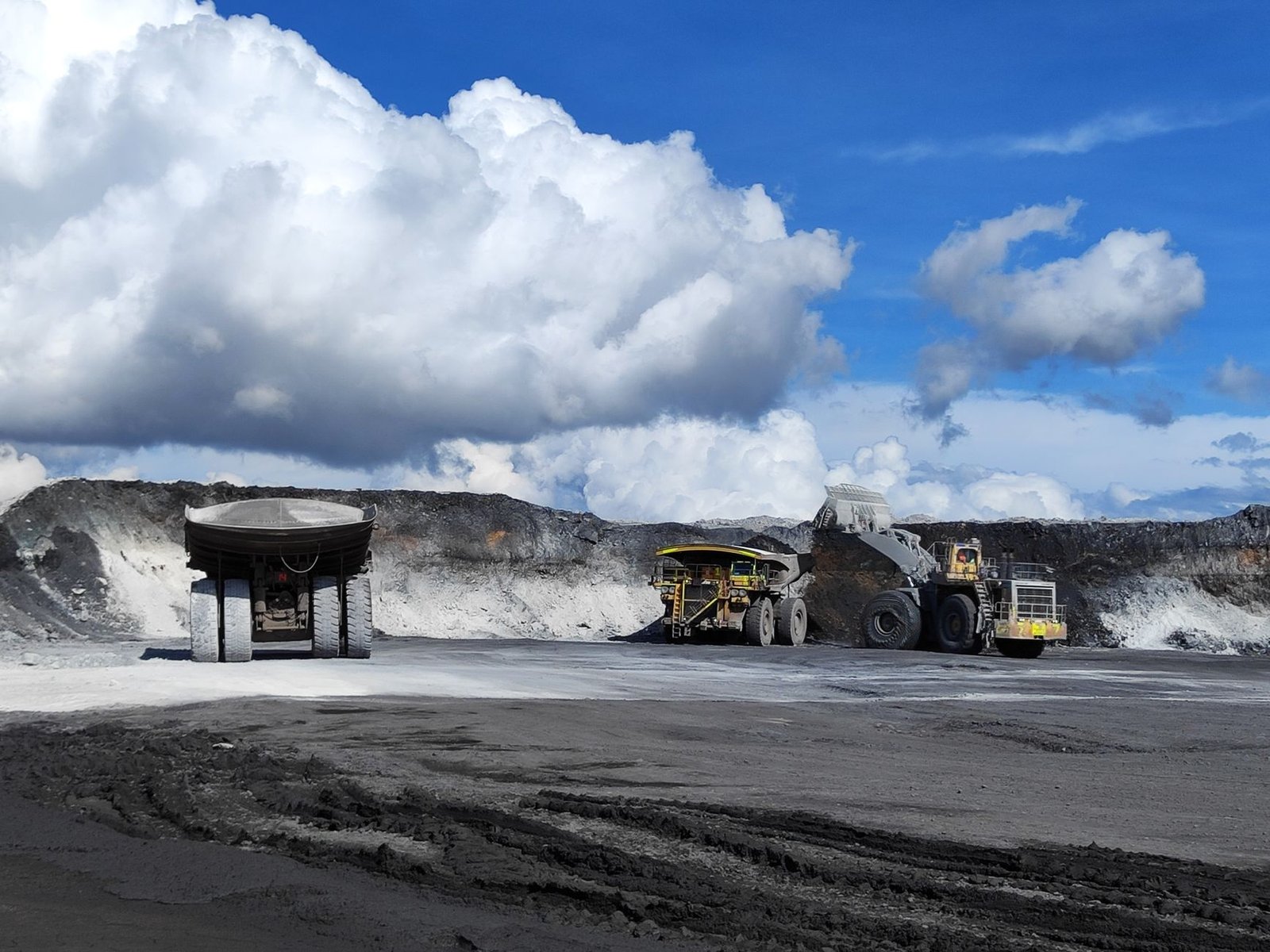 A large haul truck being loaded at the face of an open-pit mine