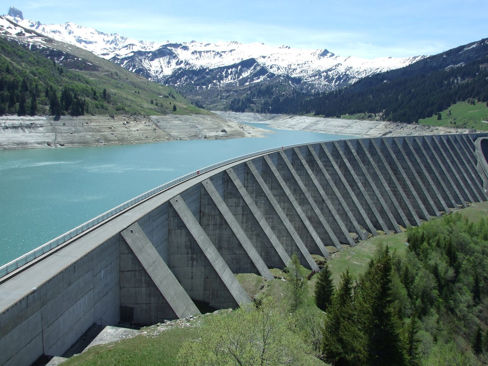 A pumped-storage hydropower reservoir held back by a dam in mountainous terrain