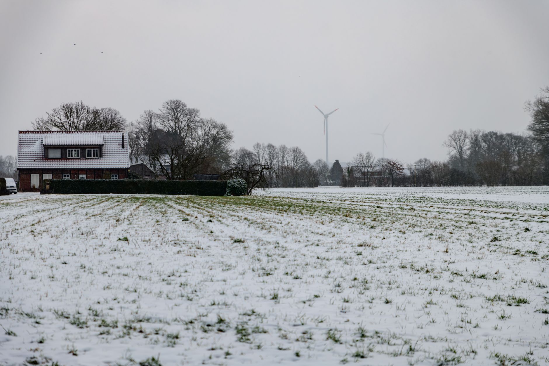 Wind turbines standing in a snow-covered winter landscape