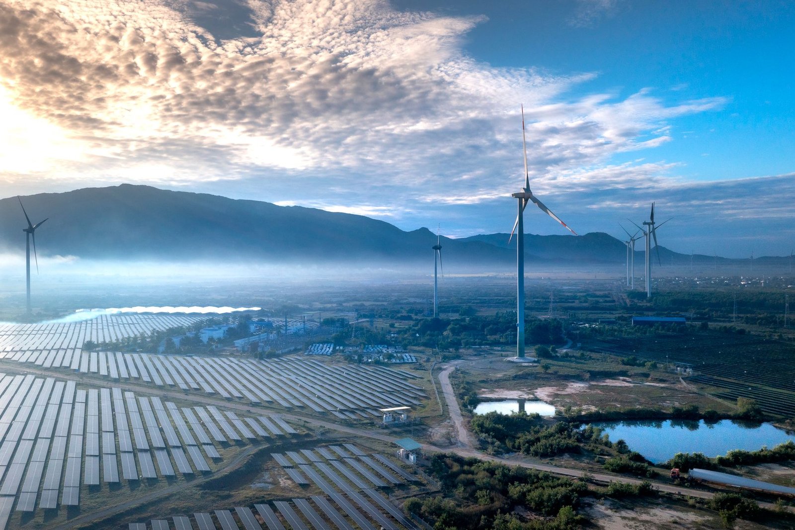Wind turbines and a solar array on a plain in northern China under a hazy sky