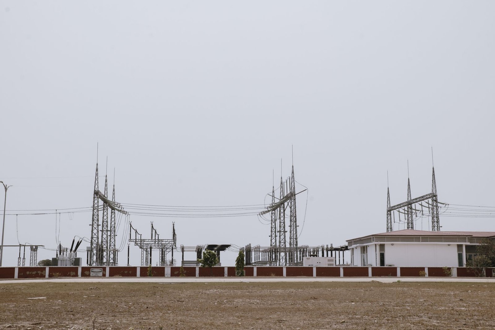 Grid-scale battery storage containers lined up at a solar and wind substation