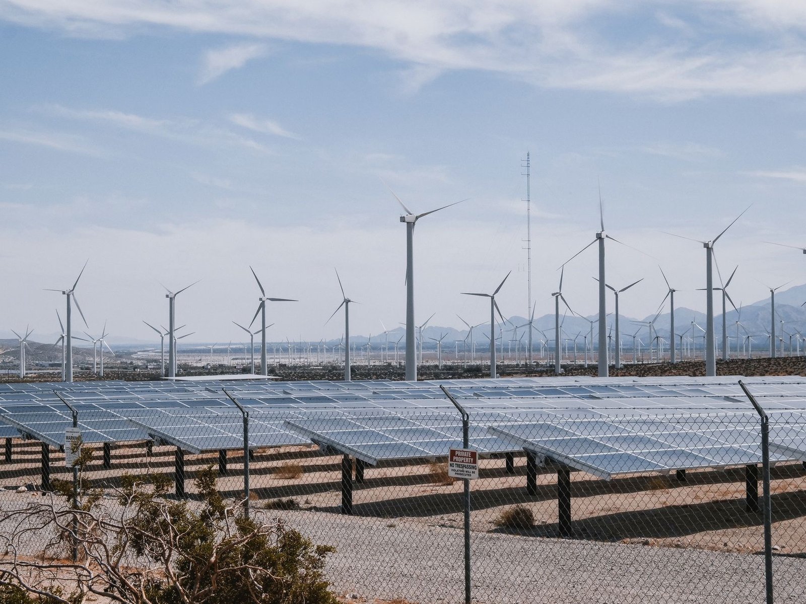 A wind farm and solar array feeding into high-voltage transmission lines