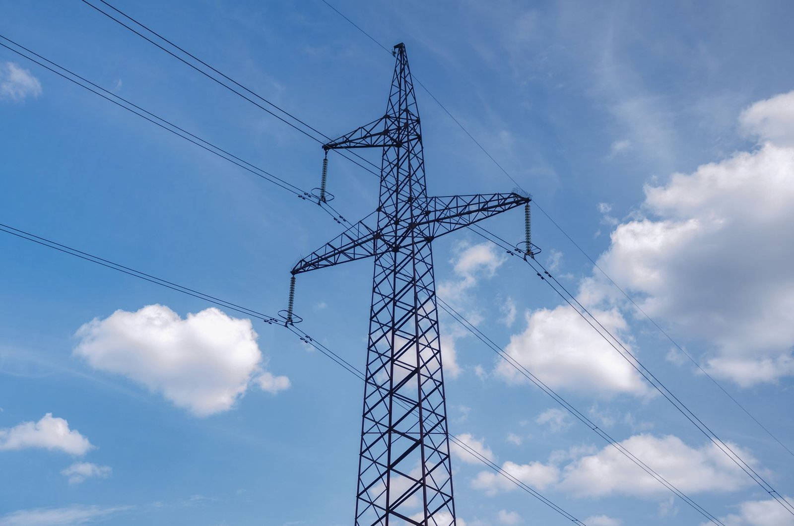 High-voltage transmission pylons carrying power to consumers, whose bills a CfD both funds and, in high-price years, credits
