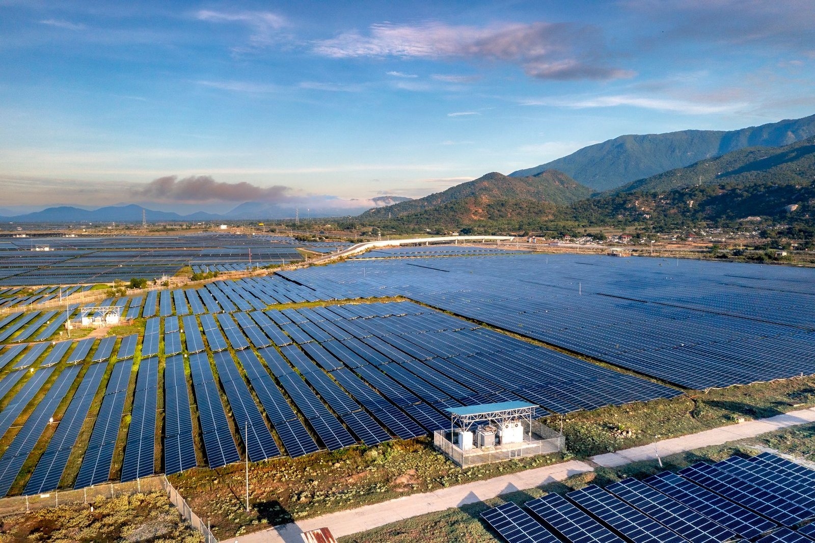 Rows of photovoltaic panels at a utility-scale solar farm under a clear sky