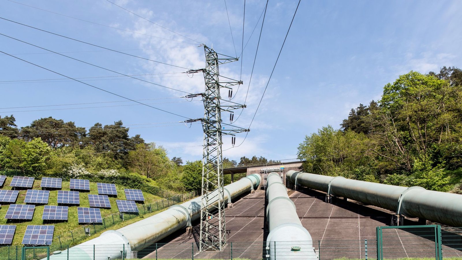 Rows of solar panels beside high-voltage transmission lines